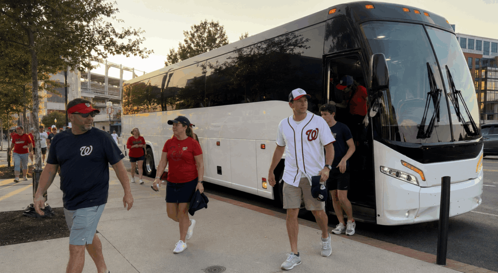 charter bus arriving at nationals park in washington dc navy yard with fans walking toward stadium for a baseball game