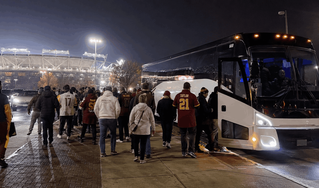 washington commanders fans boarding a charter bus outside northwest stadium after a night game.