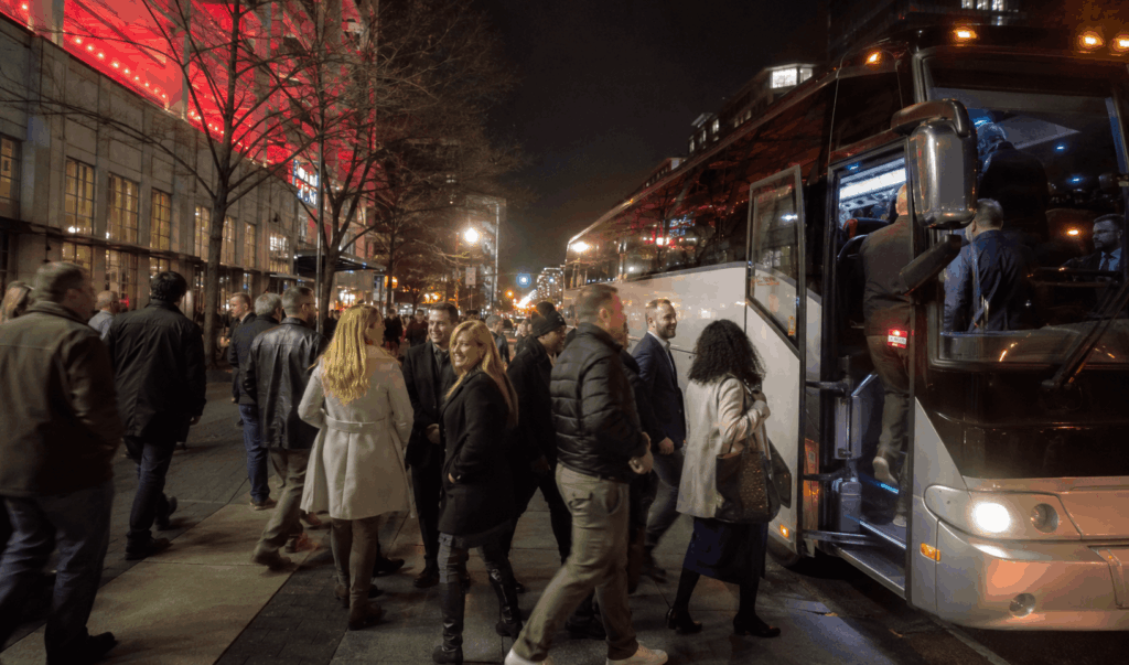 event attendees boarding a charter bus outside capital one arena at night in downtown washington, dc.
