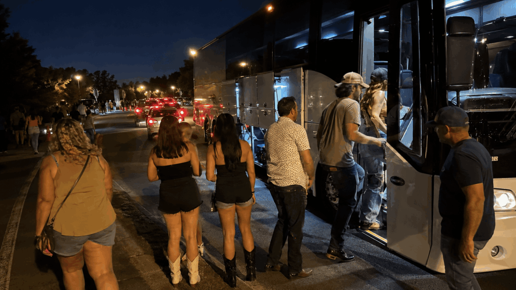 concert fans boarding a charter bus after a show at jiffy lube live in bristow virginia at night