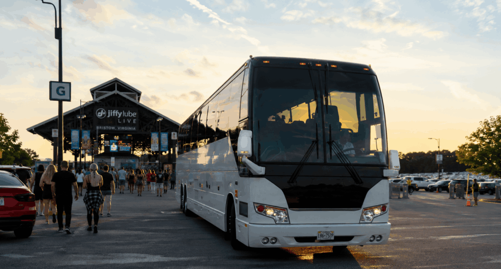 charter bus arriving at jiffy lube live concert venue in bristow va at sunset with fans entering for a summer concert