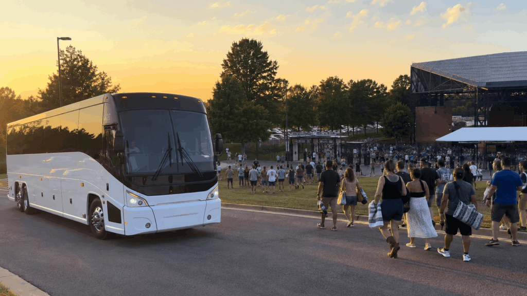 luxury charter bus arriving near jiffy lube live in bristow virginia before a summer concert at sunset