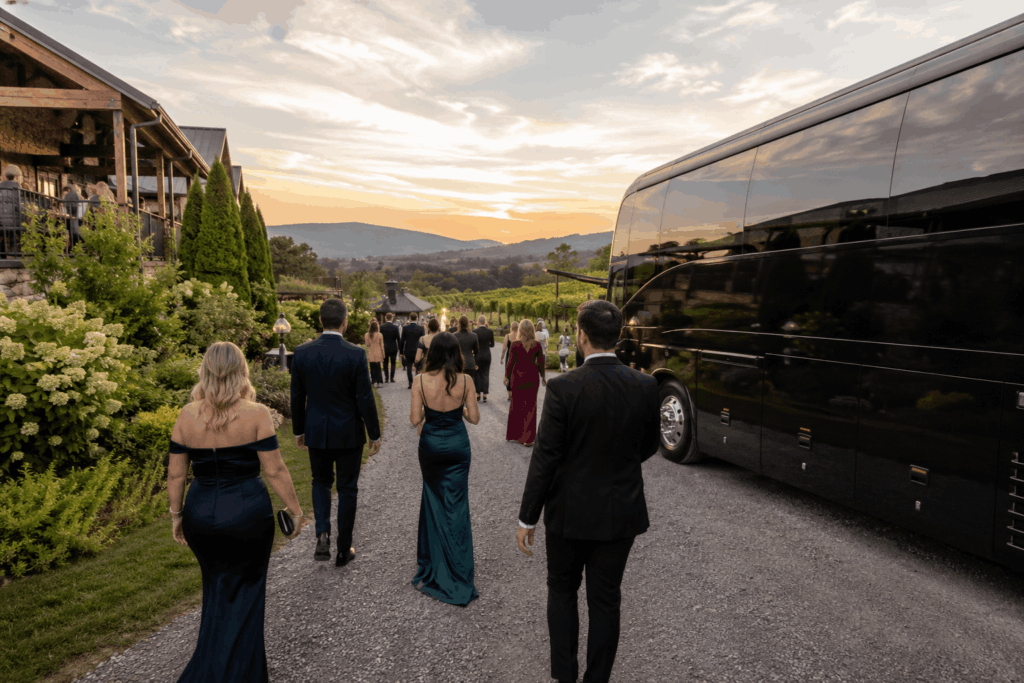luxury wedding shuttle bus arriving at a loudoun county winery wedding venue during sunset in virginia wine country