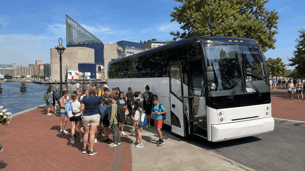 charter bus dropping students near the national aquarium at baltimore inner harbor during a school field trip